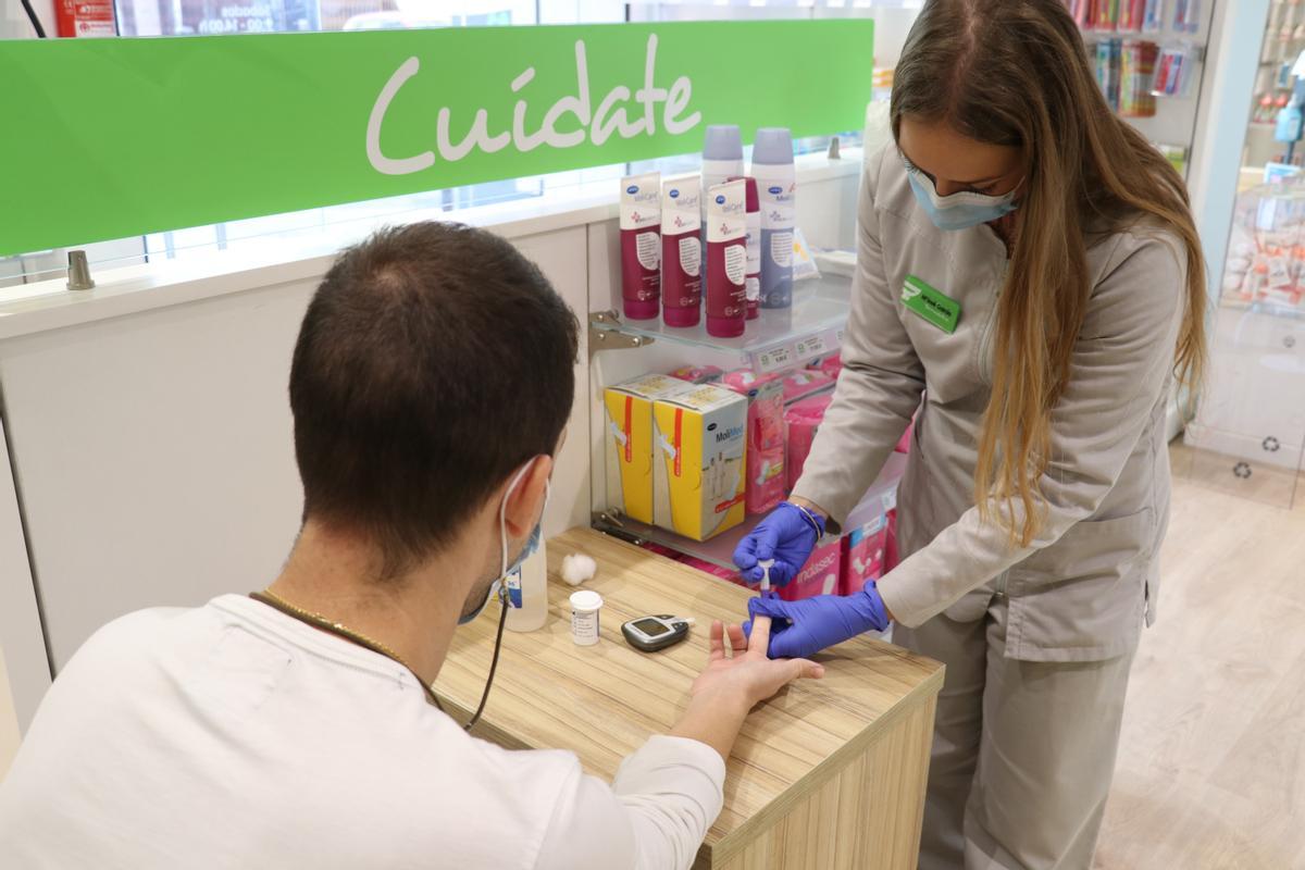 Una farmacéutica mide la glucosa en sangre de un paciente con el servicio DETECTA SUCRE.