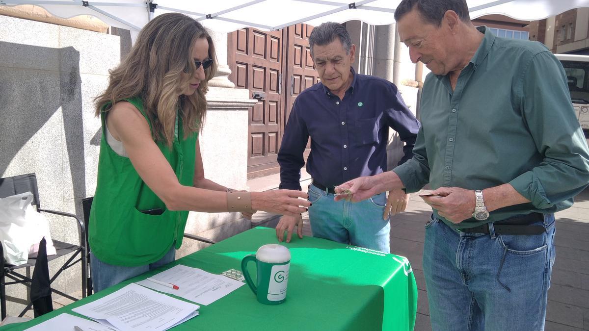 Anfonso y Vicente se acercan esta mañana a la mesa instalada en la plaza de Minayo.