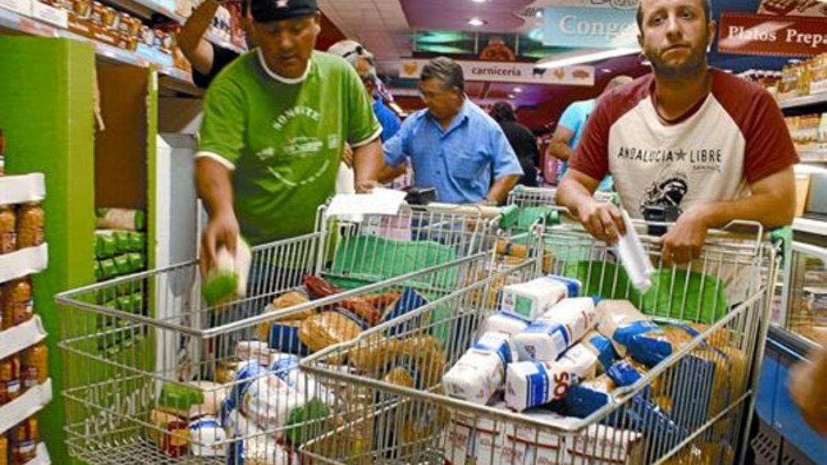 Varios sindicalistas se llevan comida del supermercado de Écija, el martes.