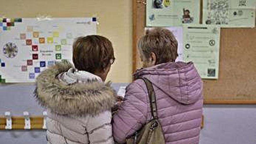 Dos mujeres consultan algunas de las papeletas.