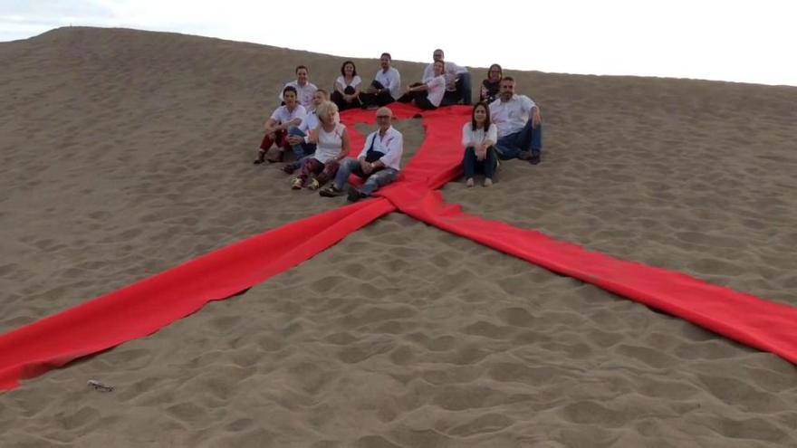 Celebración del Día del Sida en las Dunas de Maspalomas con lazo rojo