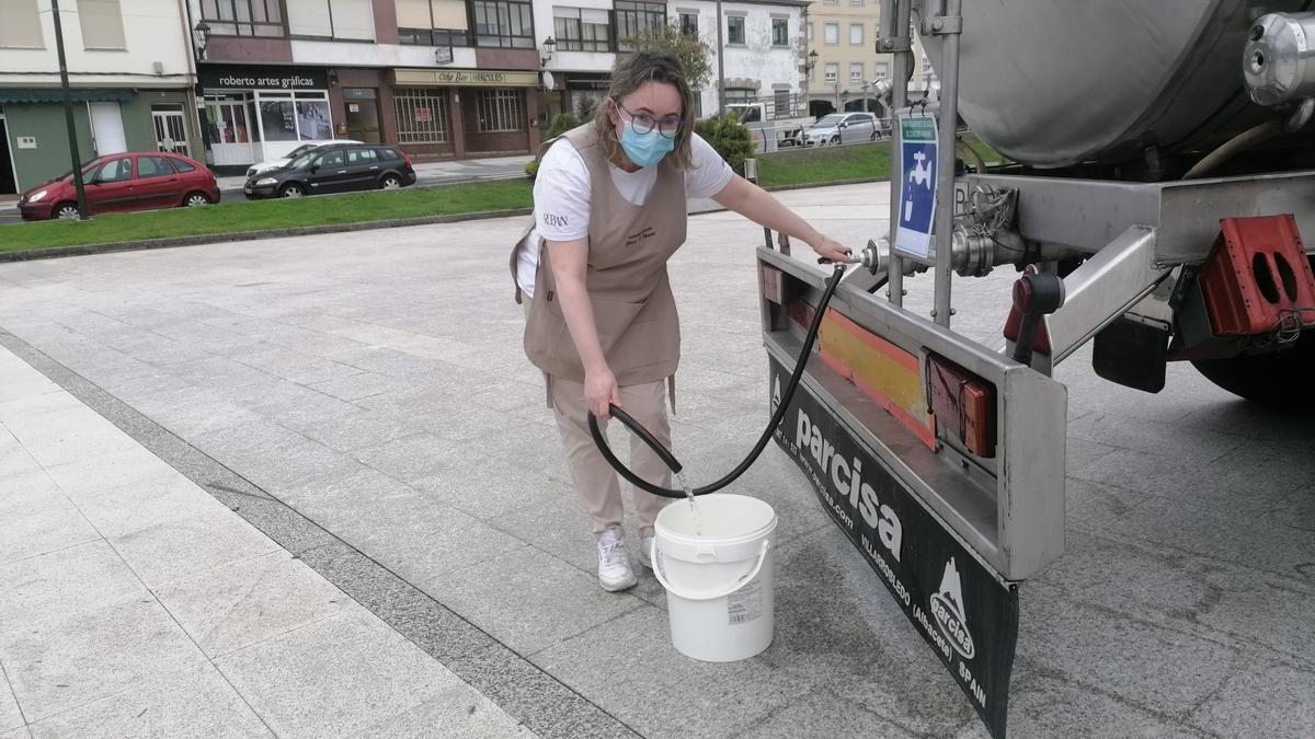 Una vecina de Teixeiro se suministra de agua a través de la cisterna instalada en la plaza