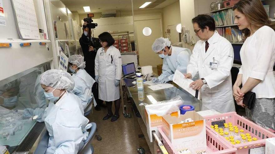 La reina Letizia observa a los trabajadores de un centro de genética médica, ayer, en Tokio.