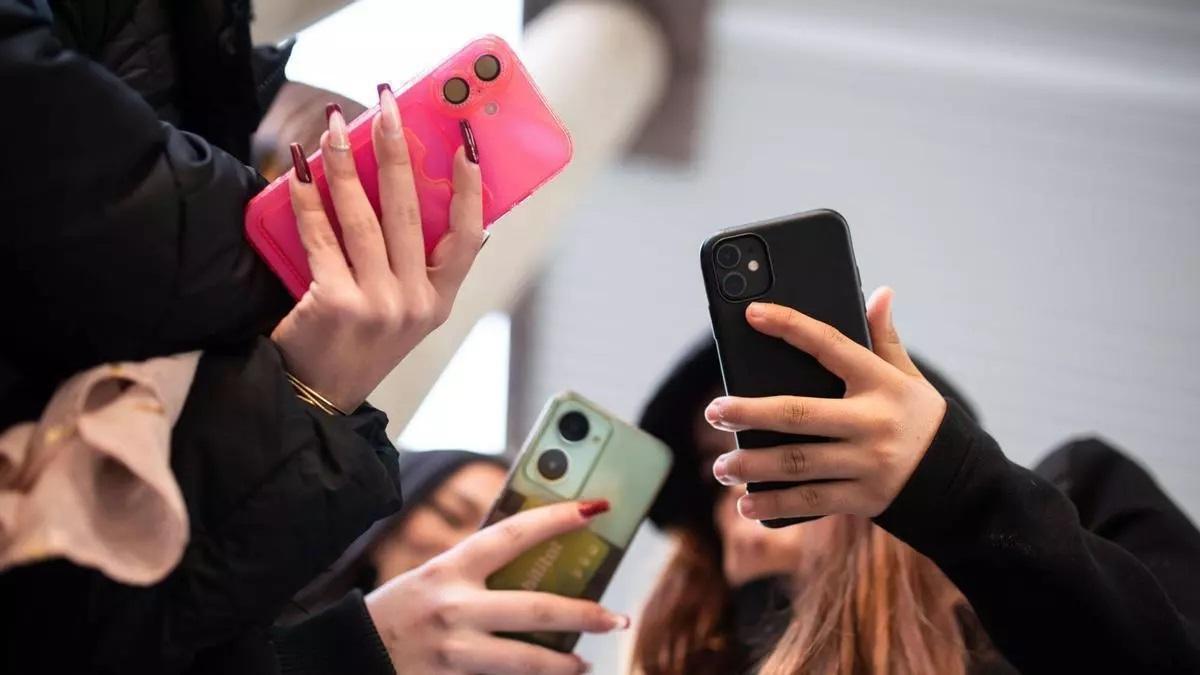 Jóvenes con sus teléfonos móviles.
