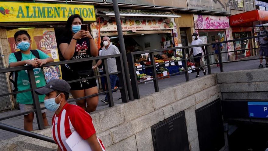 Varias personas en una boca de metro en Vallecas.