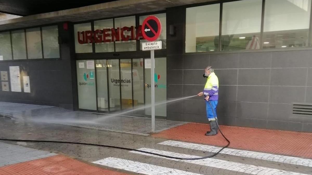 Un operario de Limasa, desinfectando la entrada a Urgencias del hospital Quirón.