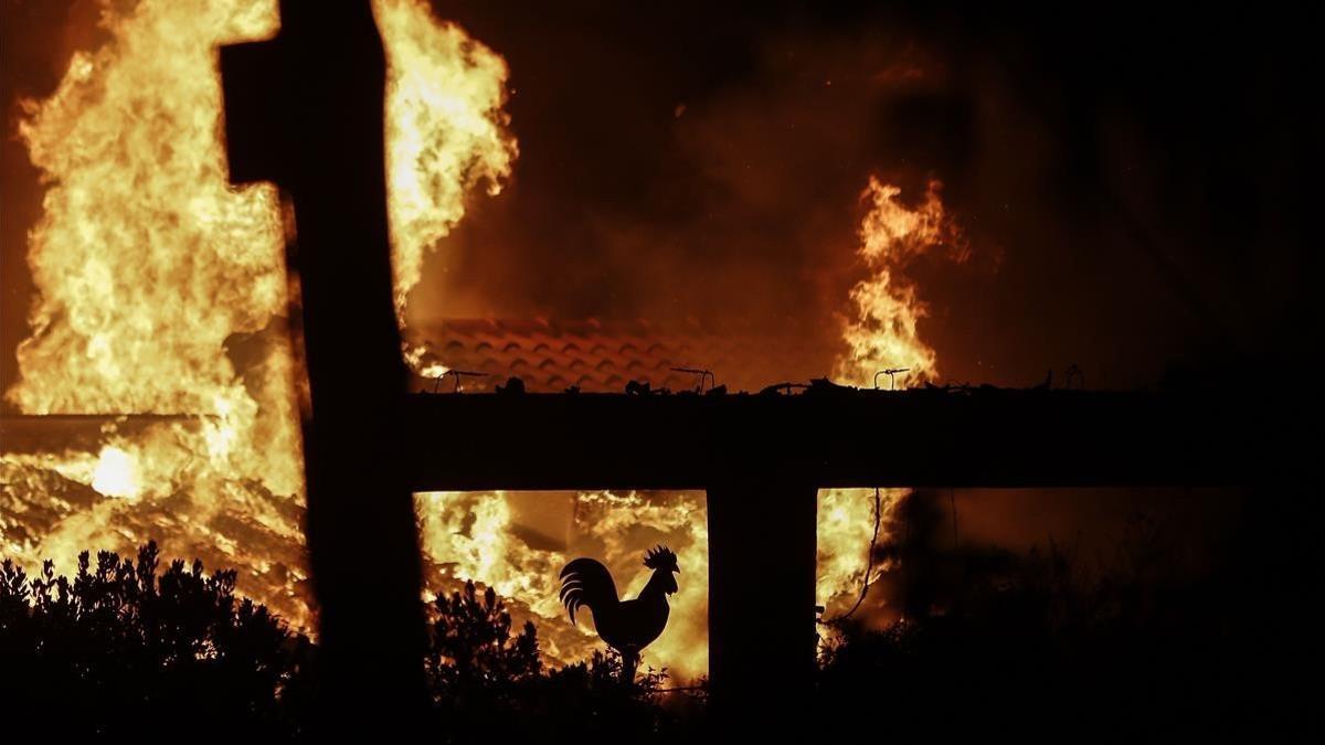 El fuego arrasa un jardín de una casa en Mati, un suburbio al noreste de Atenas.