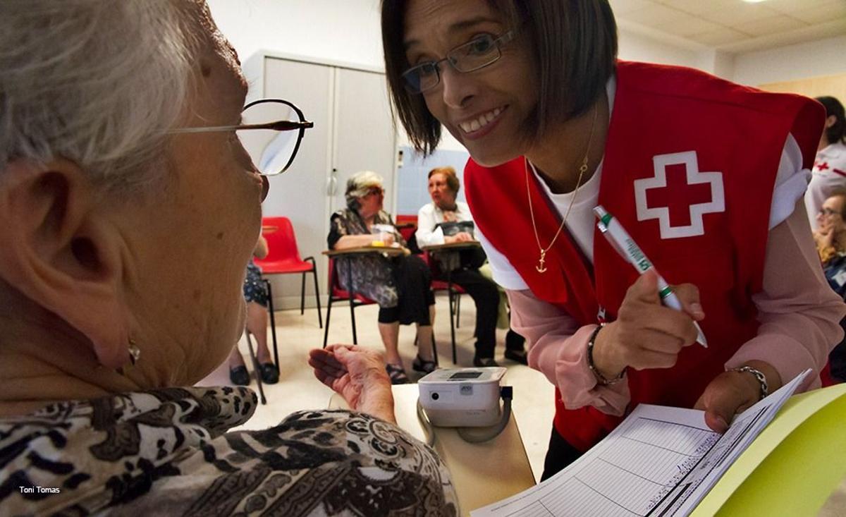 Una voluntaria de Cruz Roja con una mujer mayor.