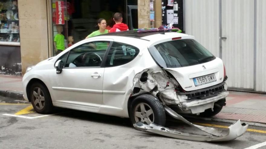 Uno de los coches afectados por el accidente en la calle José Fernandín de Piedras Blancas.