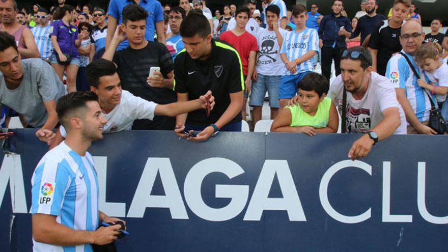 Jony Rodríguez, nuevo jugador del Málaga, firma autógrafos durante su presentación.