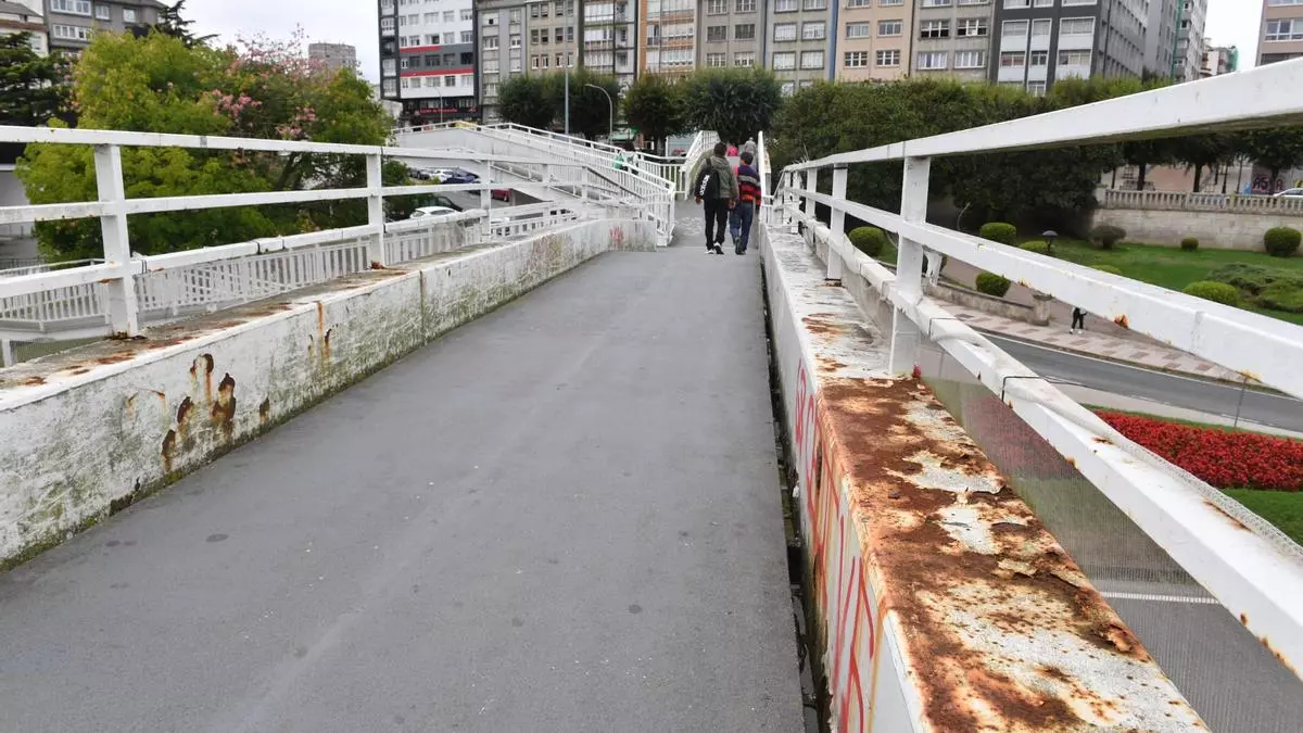 Los bomberos revisan desconchados en la pasarela peatonal de Alfonso Molina a la altura de la estación