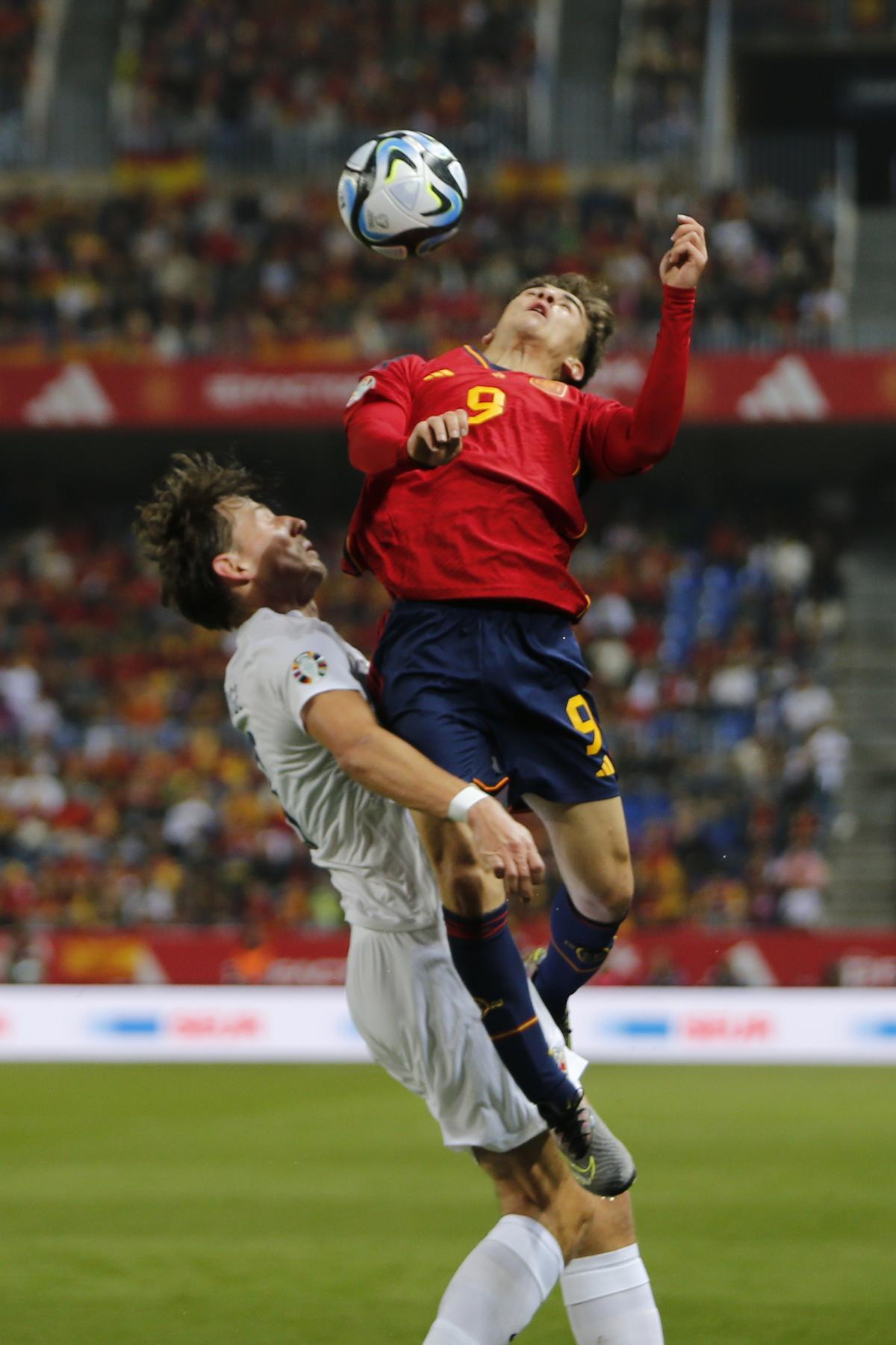 MÁLAGA, 25/03/2023.- El centrocampista de la selección española de fútbol Gavi (i) cabecea un balón ante el noruego Sander Berge, durante el partido clasificatorio de la Eurocopa 2024 que España y Noruega disputan este sábado en el estadio de La Rosaleda, en Málaga. EFE/Jorge Zapata