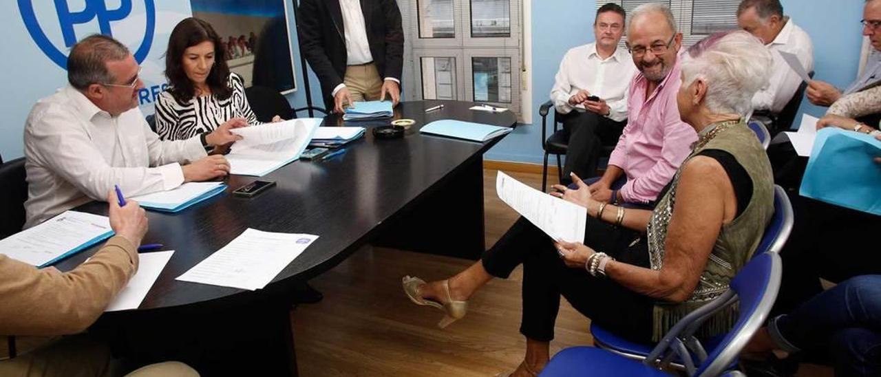 Carlos Rodríguez de la Torre, de pie, junto a Carmen Rodríguez Maniega, que preside la mesa en una reciente junta local del Partido Popular de Avilés.