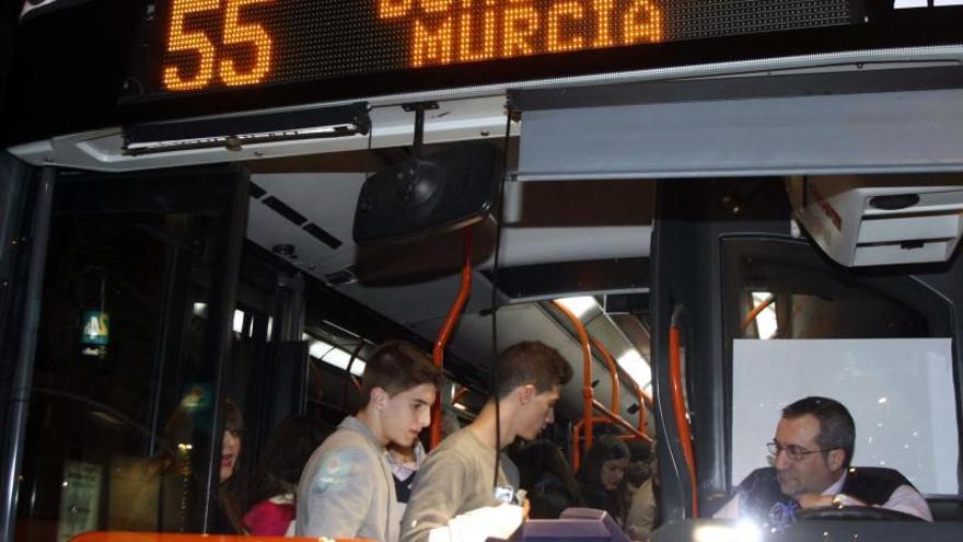 Jóevesn suben a un bus nocturno, en una foto de archivo.