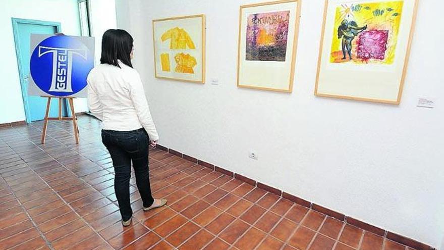 Una joven contempla tres de las obras expuestas en la primera planta del teatro municipal Juan Ramón Jiménez.
