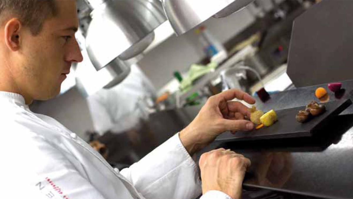 Un cocinero ultima un plato de alta cocina