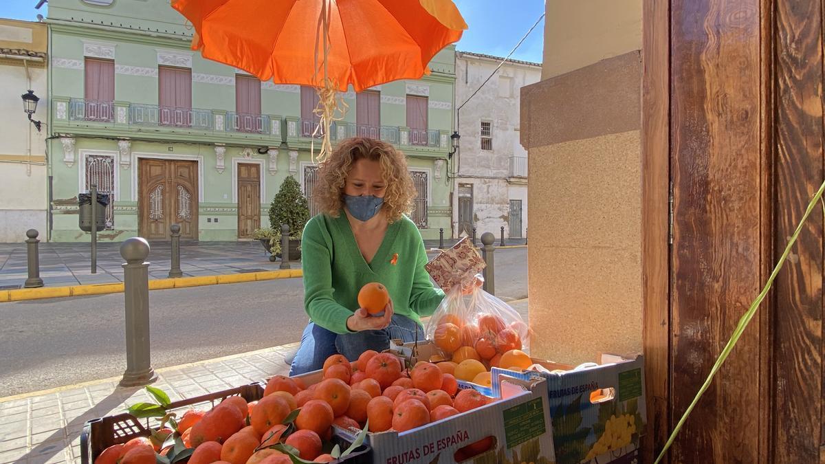 La portavoz del PP, comprando mandarinas.