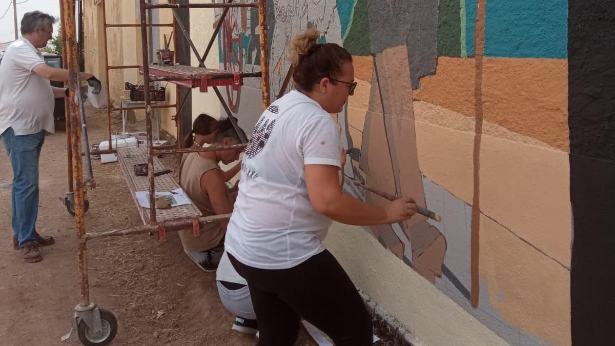 Voluntarios del proyecto pintan el nuevo mural inspirado en la Vendimia