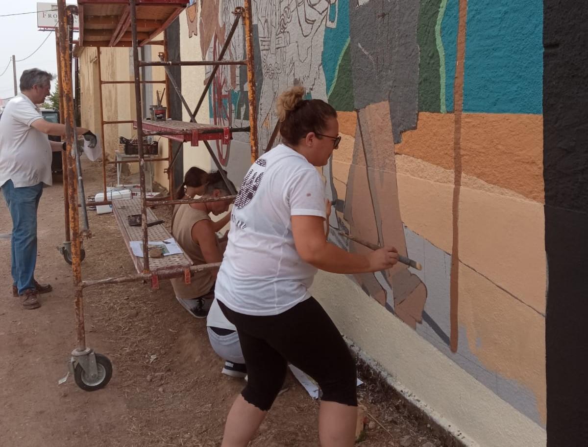 Voluntarios del proyecto pintan el nuevo mural inspirado en la Vendimia