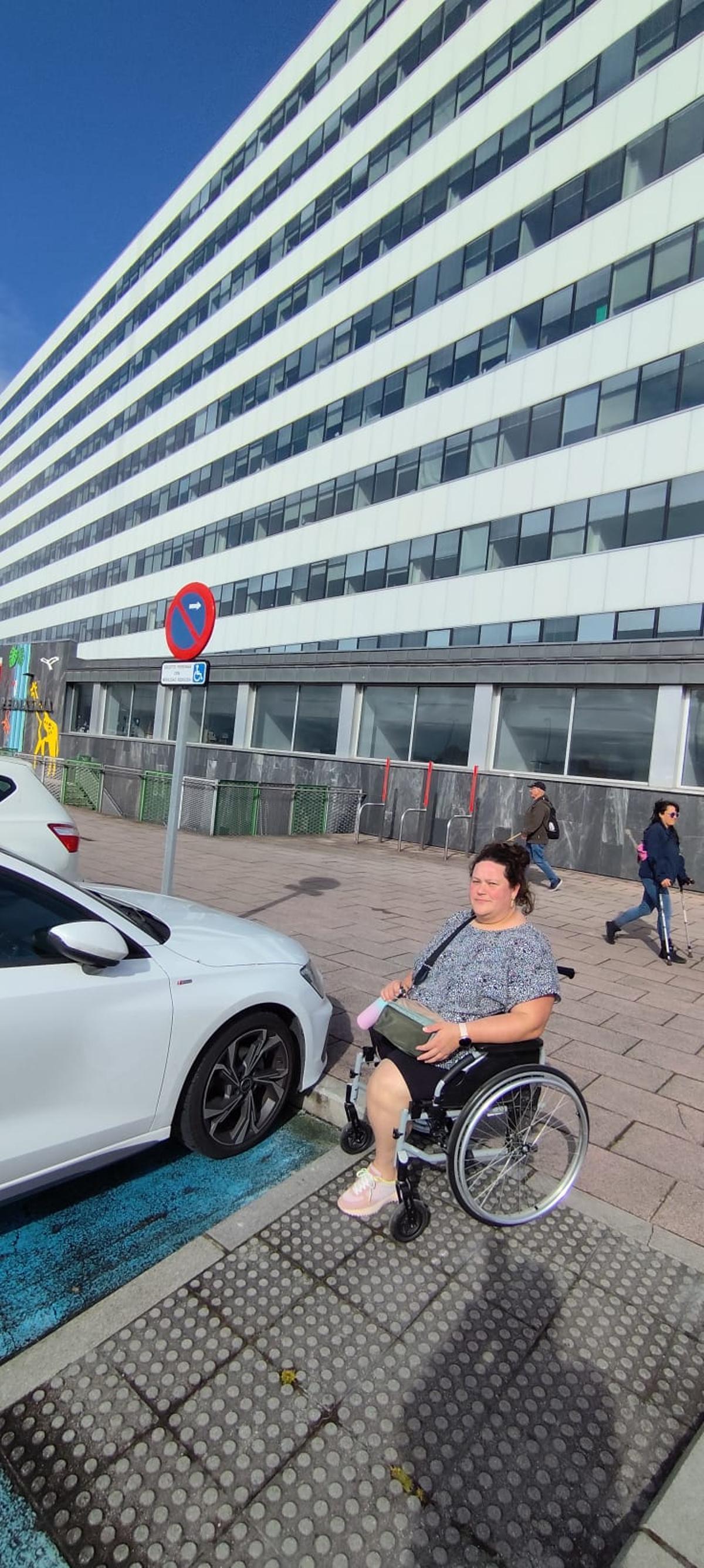María Lorenzo, junto a varios aparcamientos para discapacitados ocupados en el HUCA.