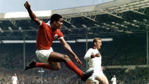 Eusèbio, con la camiseta roja del Benfica, en un partido contra el Milan en 1963.