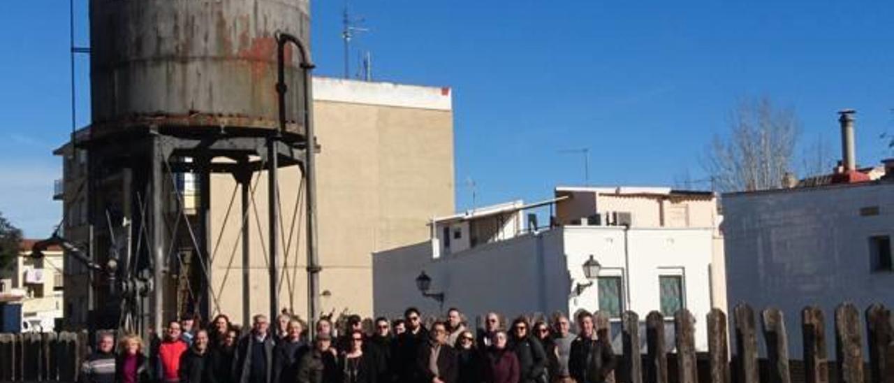 Miembros de AVAF junto al depósito de agua que se mantiene en pie en la estación de Chiva.