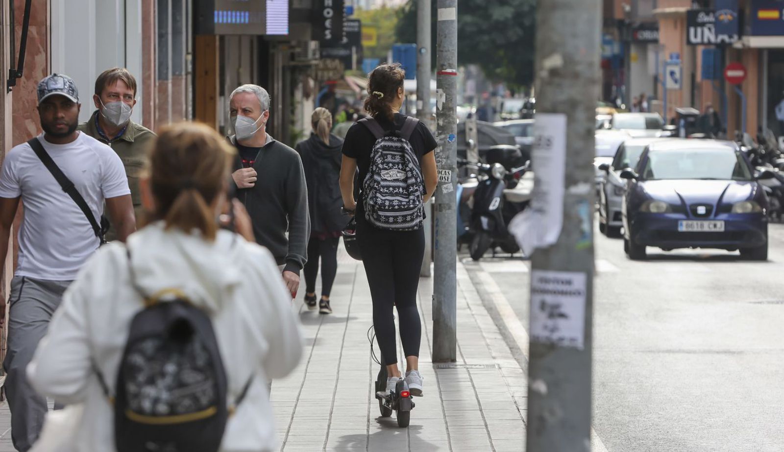 Una usuaria de patinetes va por la acera y sin casco, en una calle de Alicante este viernes.