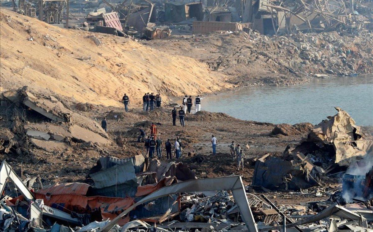 Policías y expertos forenses trabajan en la zona de la explosión de Beirut.