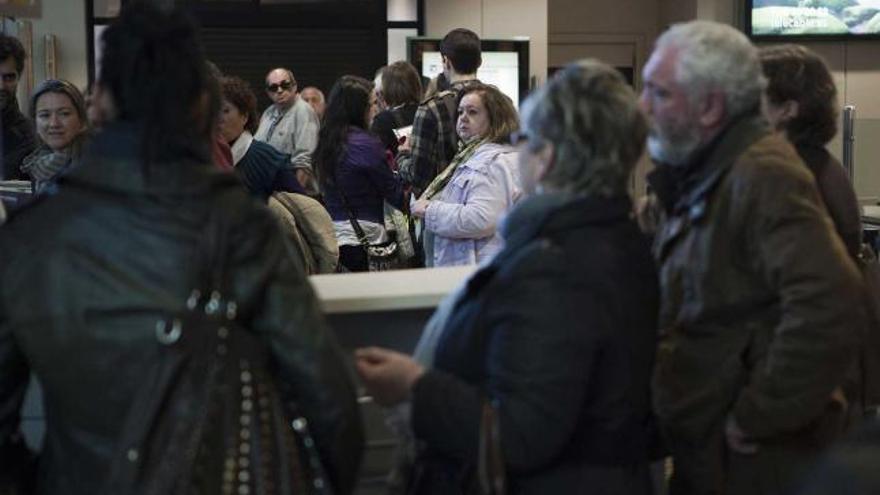 Varios pasajeros, el lunes por la tarde, haciendo cola para acceder al embarque del aeropuerto.