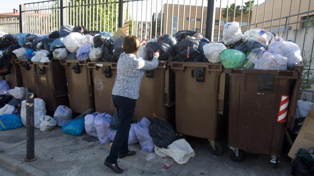 Una vecina deposita la basura en un contenedor de Ontinyent durante la huelga de basura de 2018.