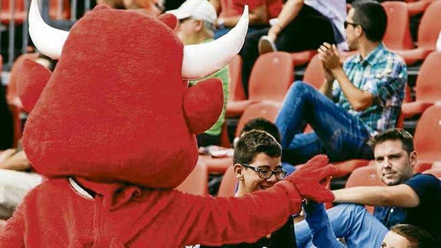 La mascota del Mallorca saluda a un aficionado en las gradas.