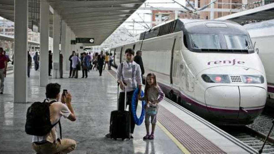 Un pasajero fotografía a su mujer y su hija tras completar el viaje del primer AVE entre Madrid y Alicante.