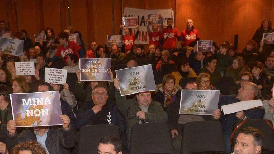 Los asistentes al pleno de A Illa mostraron carteles de protesta. // Noé Parga