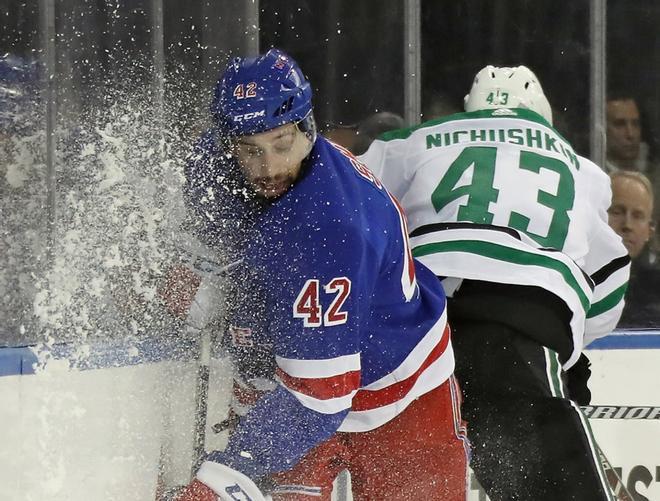 Valeri Nichushkin # 43 de los Dallas Stars golpea a Brendan Smith # 42 de los New York Rangers en los tableros durante el tercer período en el Madison Square Garden.