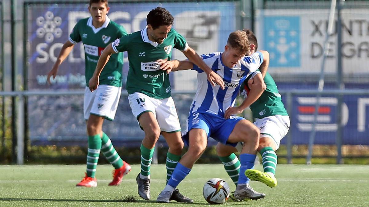 Mateo y Manu, del Coruxo, intentan arrebatarle el balón a Diego, del Leganés B, durante el partido de ayer en Fragoselo. // MARTA G. BREA