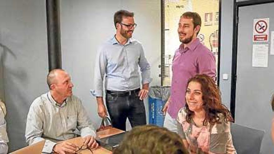 José Hila (PSOE) y Miquel Comas (Som), de pie en una reunión.