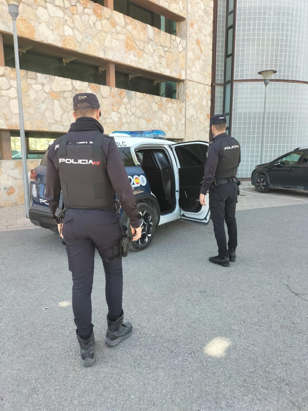 Un agente junto a un coche patrulla en la comisaría de Ibiza