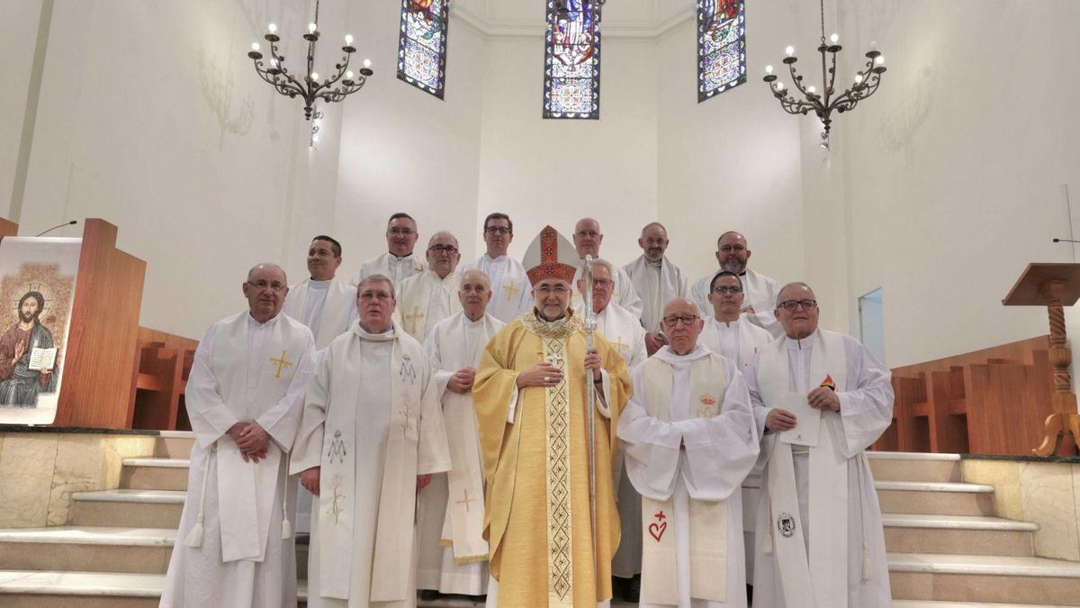 Foto de familia de los sacerdotes y padres que cumplen este año sus bodas de oro y plata en Asturias, junto al arzobispo, Jesús Sanz Montes, en el altar de la iglesia del Seminario. | IRMA COLLÍN