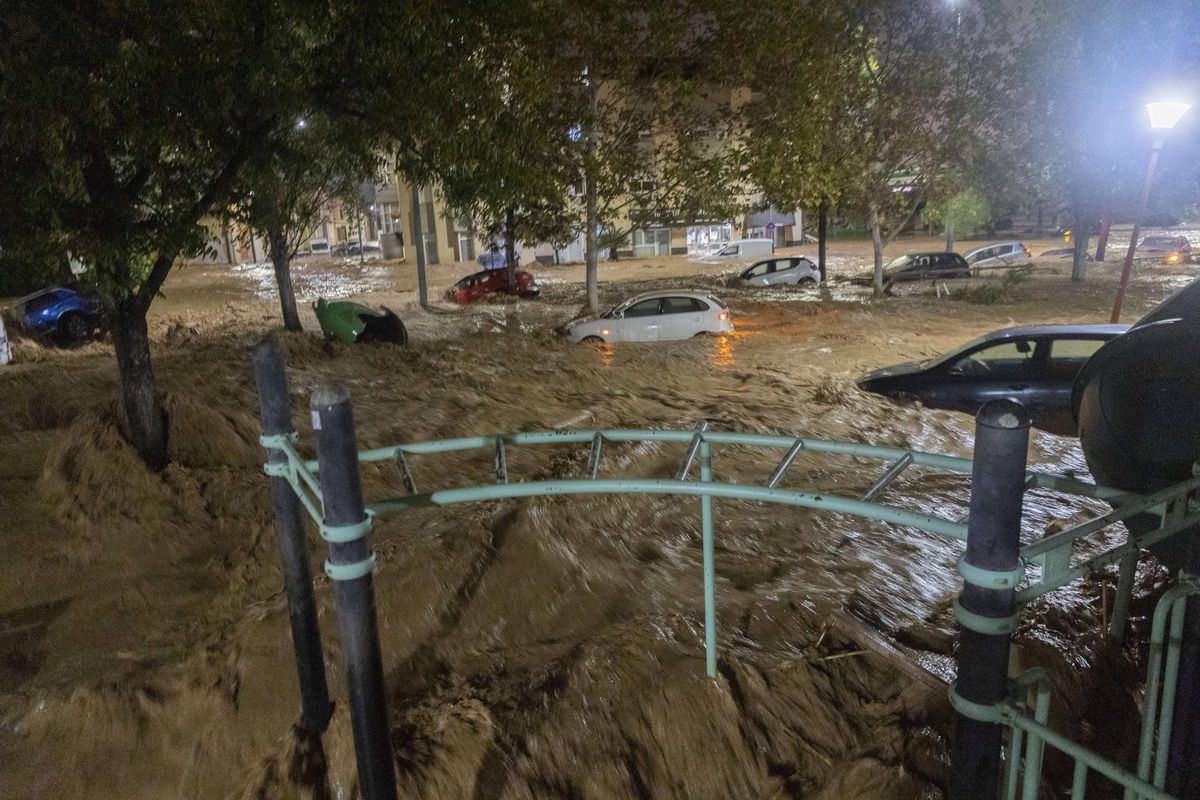 Coches arrastrados por el agua del barranco del Poyo desbordado en el Parque Villa Amparo de Paiporta, la noche del 29-O.