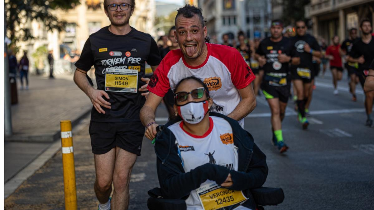 Participantes de la Cursa dels Bombers bajan felices por Via Laietana a un kilómetro de la meta