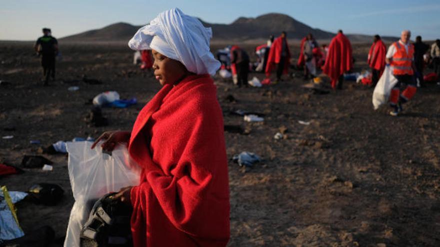 Una migrante, en primer plano, tras llegar en patera a la punta de Jandía, en el municipio de Pájara, esta semana.