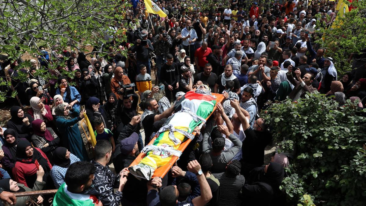 Varios palestinos portan el cuerpo de un joven muerto en un enfrentamiento con fueras israelíes.
