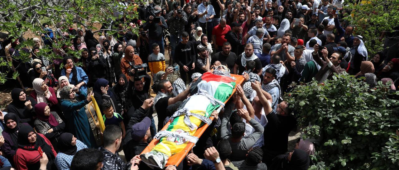 Varios palestinos portan el cuerpo de un joven muerto en un enfrentamiento con fueras israelíes.