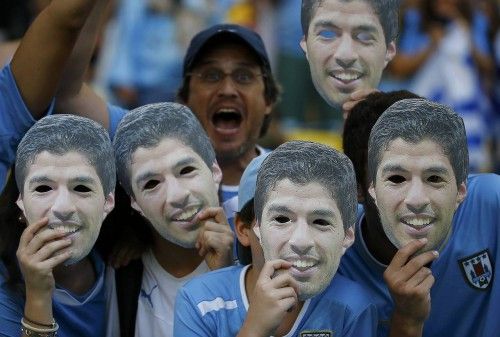 Fans of Uruguay pose with masks of Suarez before their 2014 World Cup round of 16 game against Colombia at the Maracana in Rio de Janeiro