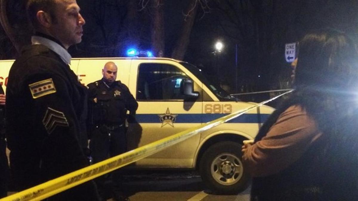 Un sargento de la policía habla con un familiar de la víctima del segundo incidente, en Chicago.