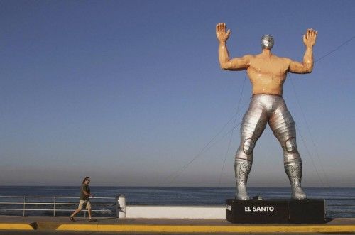 A person walks past a giant figure of famous Lucha Libre wrestler El Santo in Mazatlan