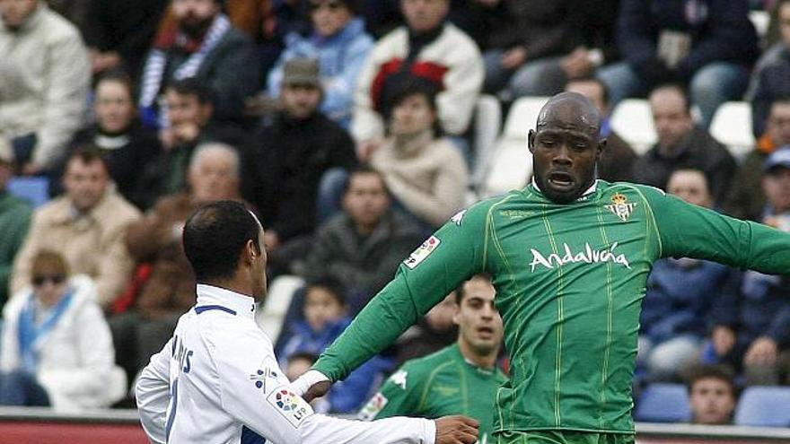 El centrocampista camerunés dle Betis Achille Emana (d) y el defensa sudafricano del Recreativo de Huelva Nasief Morris luchan por un balón durante el partido correspondiente a la vigésima jornada de liga en primera división que esta tarde han disputado Recreativo de Huelva y Real Betis en el estadio Nuevo Colombino de Huelva. EFE/JULIAN PEREZ