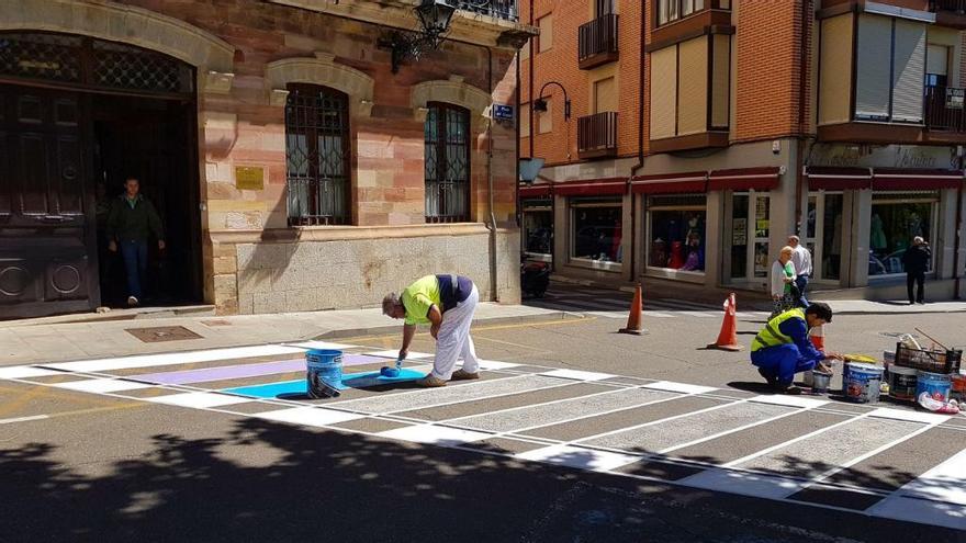 Operarios municipales pintando el paso de cebra con los colores de la bandera LGBT.