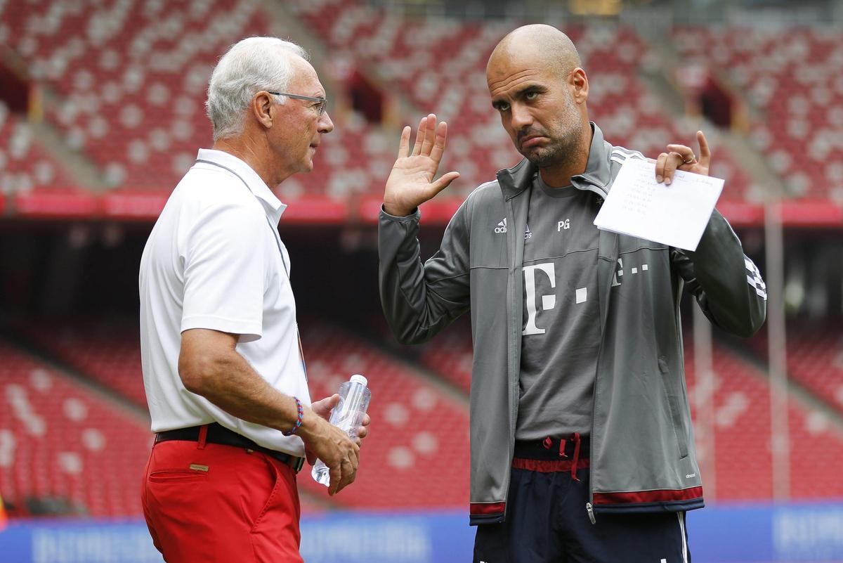 El técnico del Bayern de Múnich, Pep Guardiola, conversa con Franz Beckenbauer, presidente de honor del equipo, durante un entrenamiento del equipo en el estadio Nacional de Pekín,