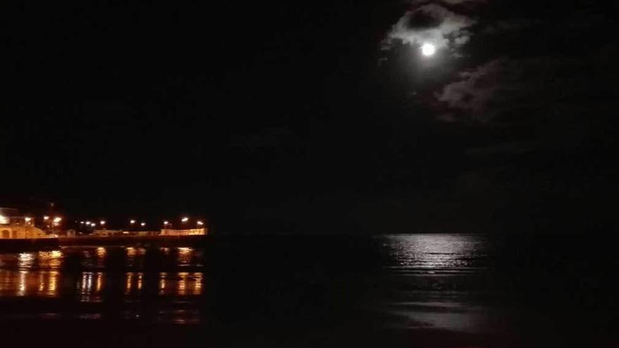 La &quot;superluna&quot;, sobre las aguas del muelle de Luanco, el lunes.